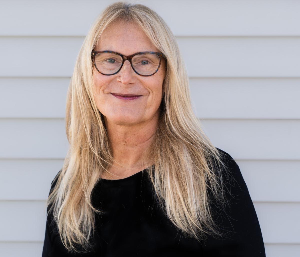 A headshot of Jillian Celentano, who will be coordinating the panel; she is an older white woman with blonde hair and glasses smiling at the camera.