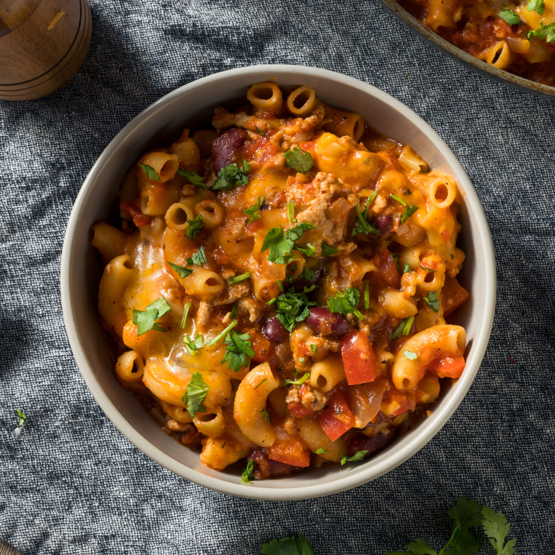 A bowl of mac and cheese topped with chili