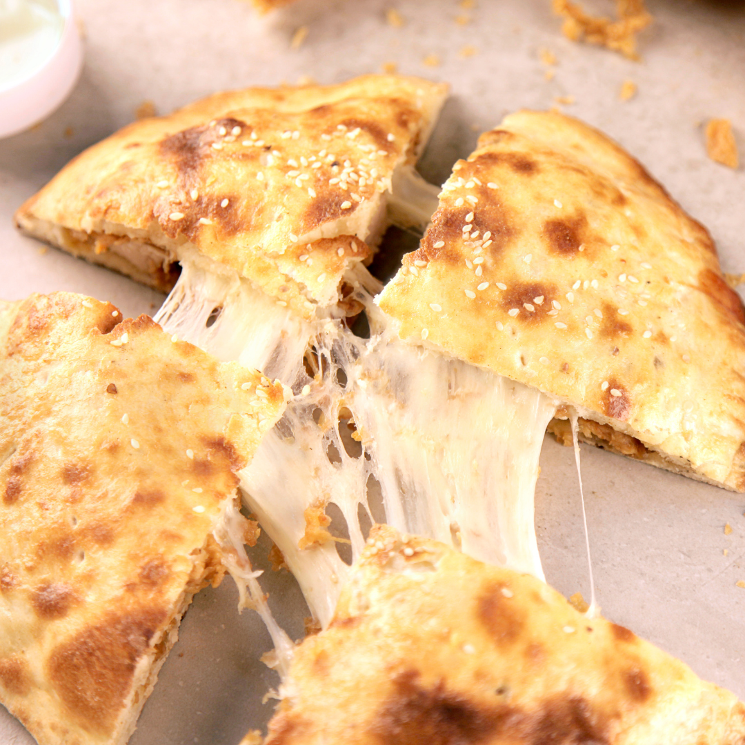 Four pieces of cheese stuffed naan being pulled apart