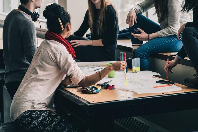 A stock image of diverse teenagers working on a group project together